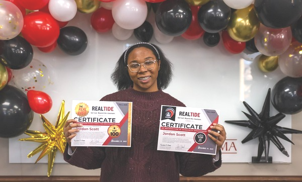 Jordan Scott poses with two certificates that she has earned.