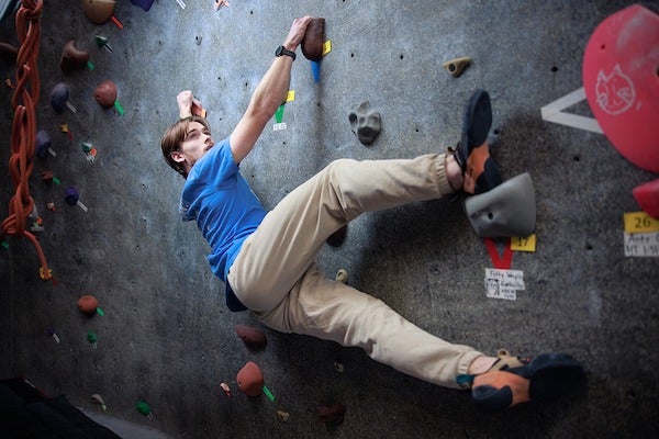 Ciarnan Looney climbs a rock wall.